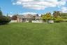 Rear elevation showcasing the home’s fenced backyard, classic chimney, and inviting sunroom.