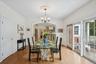 Sophisticated dining area adorned with arched walkways, rich wood-finished floors, and a statement chandelier.