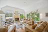 An exquisite living area showcasing vaulted ceilings, rich oak hardwood floors, and a timeless wood-burning fireplace, beautifully encased in floor-to