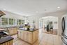 Gourmet kitchen showcasing granite countertops, a generous island, custom cabinetry with glass inserts, an inviting eat-in area, recessed lighting, an