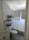 Bathroom with light tile patterned flooring, vanity, lofted ceiling, and curtained shower