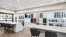Kitchen with a kitchen breakfast bar, white cabinets, recessed lighting, and light stone counters