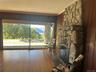 Living area featuring crown molding, wood finished floors, a stone fireplace, and wood walls