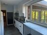 Kitchen with white cabinetry, white appliances, and range hood