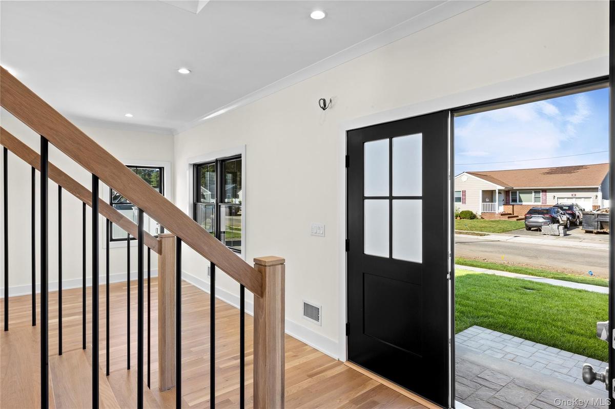 Foyer entrance with stairway, light wood-style floors, and recessed lighting