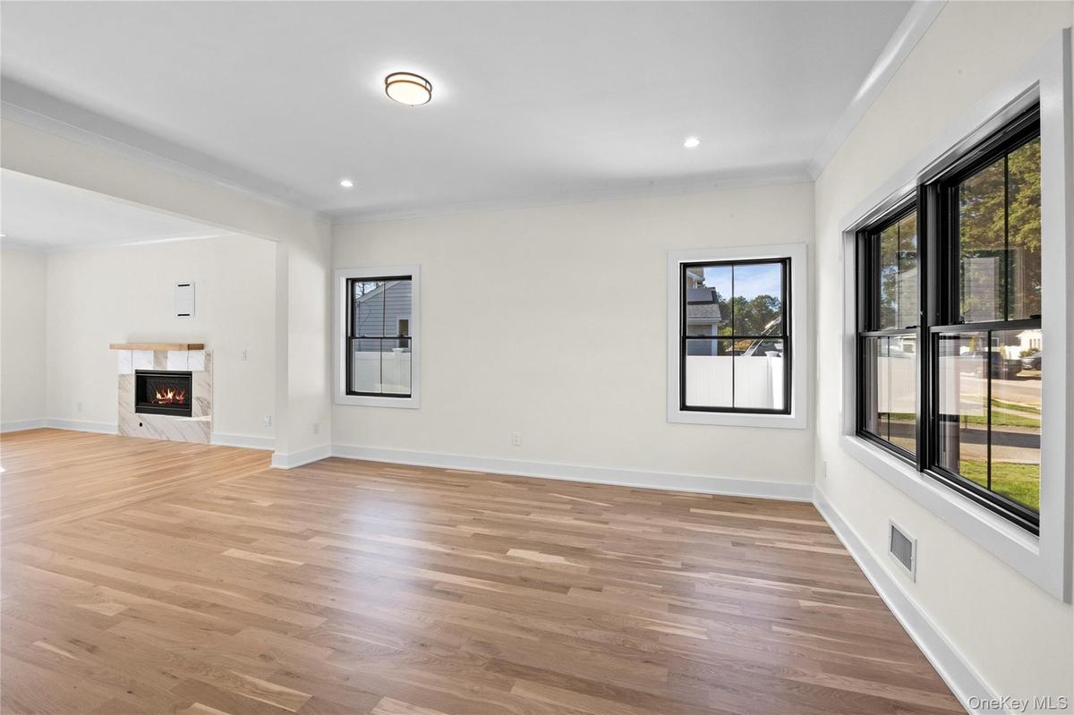 Unfurnished living room featuring a premium fireplace, light wood-style floors, crown molding, and recessed lighting