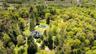 Aerial view of property and surrounding area with a forest