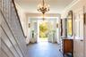 Foyer entrance featuring a chandelier, wood finished floors, stairs, crown molding, and baseboards