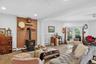 Living area featuring ceiling fan, a wood stove, wood finished floors, recessed lighting, and baseboard heating