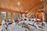 Living room featuring lofted ceiling, wood walls, wood ceiling, stairway, and a skylight