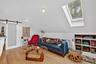 Living room featuring a barn door, wood finished floors, a skylight, and lofted ceiling