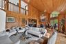 Living room with high vaulted ceiling, wooden walls, a chandelier, and wooden ceiling
