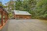 View of home's exterior featuring stairs, log exterior, a garage, a metal roof, and view of scattered trees
