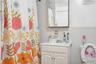 Bathroom with vanity, tile walls, and a shower with shower curtain