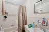 Full bath featuring shower / bath combo, a textured ceiling, vanity, and tile walls
