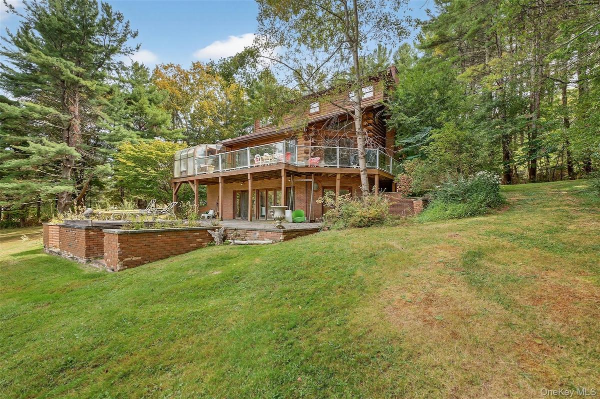 Rear view of house with a yard and a deck