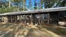 Back of property with a sunroom, an outdoor structure, and exterior structure