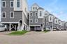 View of front of home with stairs, a residential view, asphalt driveway, and a carport