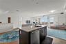 Kitchen with open floor plan, an island with sink, healthy amount of natural light, and light wood-style flooring