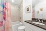 Bathroom featuring shower / tub combo with curtain and vanity