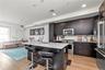 Kitchen with appliances with stainless steel finishes, a kitchen bar, light wood-type flooring, decorative backsplash, and recessed lighting