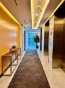 Hallway with elevator, light tile patterned flooring, recessed lighting, and expansive windows