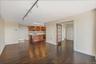 Unfurnished living room featuring rail lighting, dark wood finished floors, and french doors