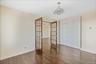Unfurnished bedroom with french doors, dark wood-style floors, and a closet