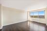 Unfurnished room with dark wood-style floors and radiator heating unit