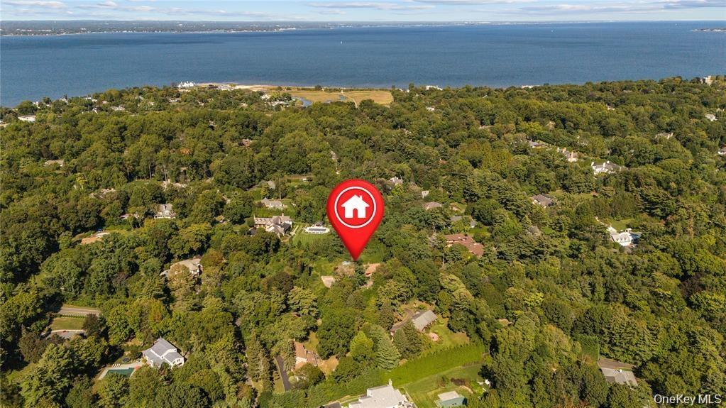 View of property location with a nearby body of water and a heavily wooded area