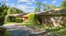 Ranch-style home featuring brick siding, driveway, and a front lawn