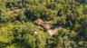 Aerial view of property and surrounding area featuring a heavily wooded area