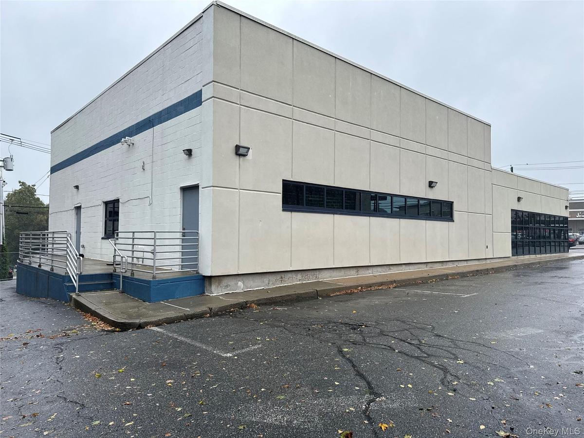 View of building exterior featuring uncovered parking