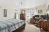 Bedroom featuring light colored carpet, crown molding, and a desk