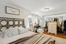Bedroom with wood finished floors, a closet, and crown molding