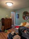 Bedroom with a baseboard heating unit and light wood-type flooring