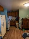 Kitchen featuring sink, white appliances, decorative backsplash, and light wood-type flooring