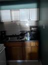 Kitchen featuring dark stone counters, sink, white cabinetry, stove, and tasteful backsplash