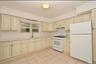 3rd Floor Kitchen with cream cabinetry, white appliances, light tile patterned floors, and under cabinet range hood