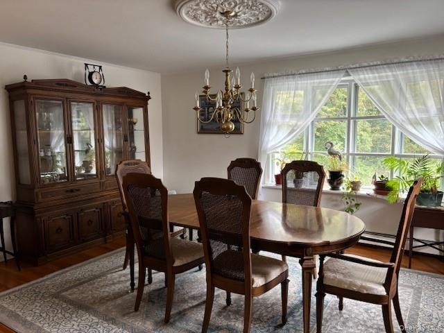 Dining area featuring wood finished floors and a chandelier