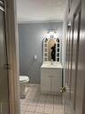 Half bathroom with ornamental molding, light tile patterned floors, and vanity