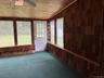 Unfurnished sunroom featuring vaulted ceiling and a ceiling fan