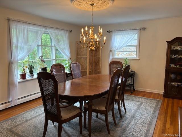 Dining space featuring wood finished floors and a chandelier