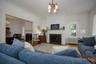Living area featuring a fireplace with flush hearth, a chandelier, radiator heating unit, crown molding, and wood finished floors