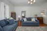 Living room with wood finished floors, ornamental molding, and a chandelier