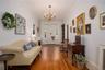 Foyer featuring wood-type flooring, a chandelier, and crown molding