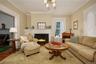Living room with a fireplace, wood finished floors, and ornamental molding