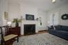 Living area with radiator heating unit, wood finished floors, ornamental molding, and a high end fireplace
