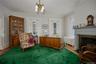 Living area featuring a chandelier, radiator heating unit, ornamental molding, a fireplace with flush hearth, and dark wood-style flooring