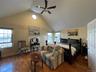 Bedroom featuring wood finished floors, high vaulted ceiling, and ceiling fan
